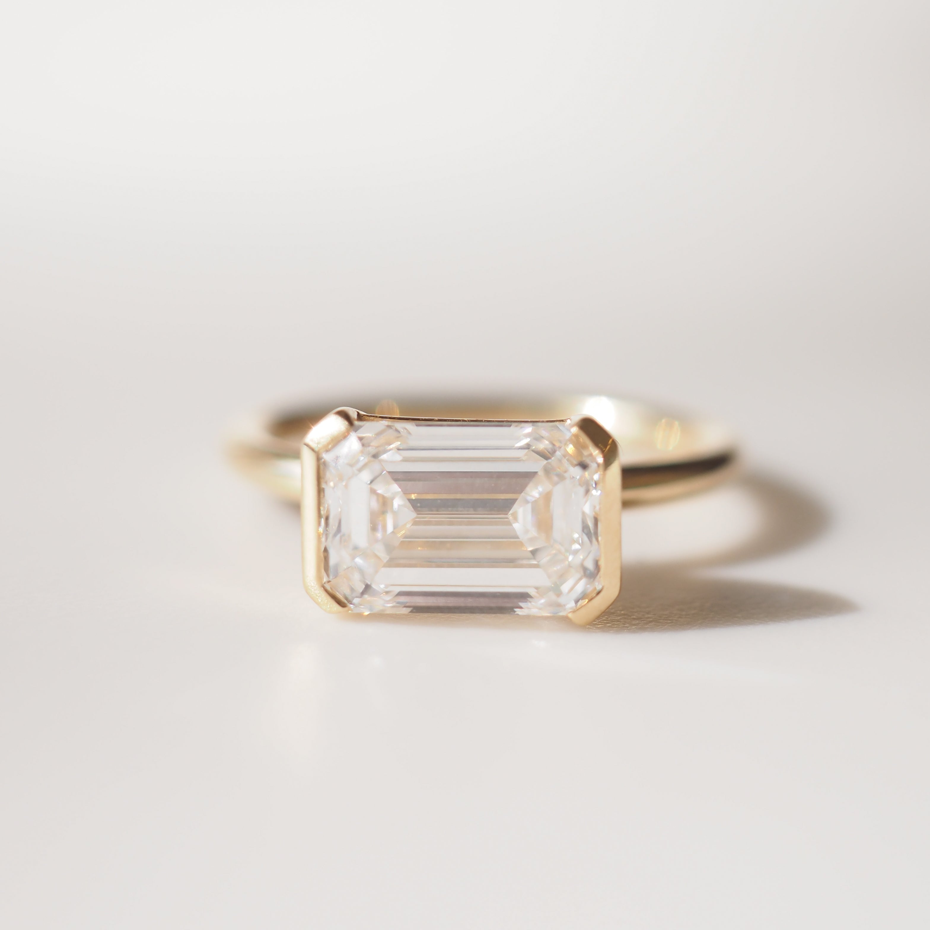 Evie | 2.5ct East West Emerald Half Bezel Solitaire Ring